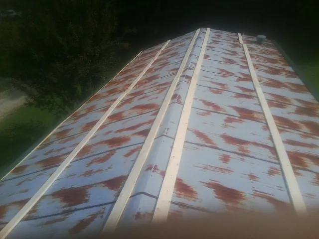 Rusted metal roof panels with new wood purlins before replacement — Storm Damage Roof Repair in Oak Brook by Roofing Brothers