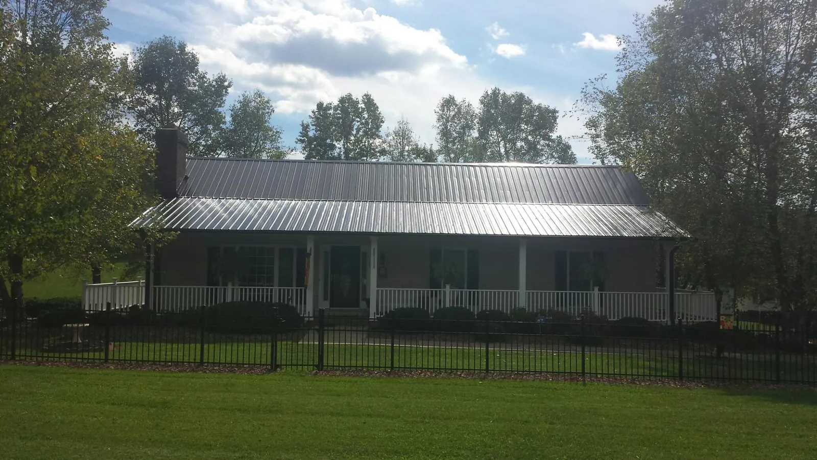 Gray metal roof on a brick ranch with a full width front porch — Gutter Guard Installation work by our crew in Oak Brook